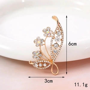 Detailed view of a golden flower brooch with rhinestones showing 6cm x 3cm dimensions