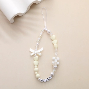 Detail of DIY beaded phone strap with cream heart charms and checkered cube beads