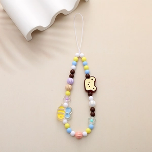 Beaded bear and bee phone charm strap with colorful resin beads on a minimal display