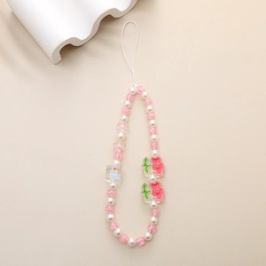 Detail of pink cracked beads and acrylic cupcake charms on a beaded phone strap