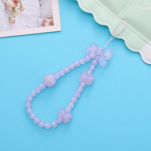 Détail d'une dragonne en perles violet clair avec charms ours et nœuds irisés
