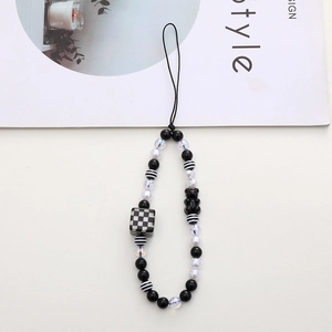 Detail of beaded phone strap with black and white checkered cubes and a cute bear charm