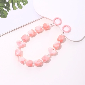 Pink heart-shaped acrylic beads and translucent cubes on a phone chain with spring hooks