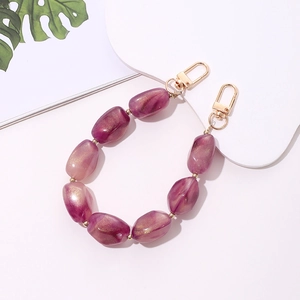 Detailed shot of purple marble acrylic stone phone strap with golden beads and clasps