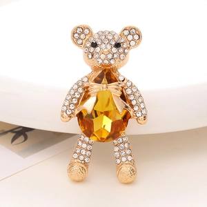 Macro shot of teddy bear brooch with yellow pear-cut crystal and sparkling rhinestones