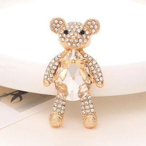 Detailed close-up of golden bear charm with white rhinestones and large crystal