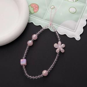 Détail du cordon de téléphone perlé rose nacré avec des breloques florales de lapin