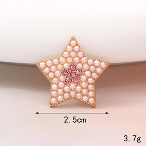 Dettaglio macro del ciondolo a stella con perle, strass rosa, dimensione 2,5 cm e peso 3,7 g