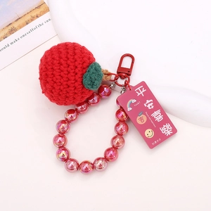Detailed shot of handmade crochet red apple keychain with pink beads and gift tag