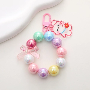 Pastel beaded bear keychain with iridescent pearls and a pink bow on white background