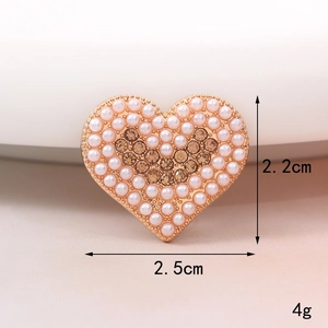 Vista macro dell'accessorio a cuore con perle e strass per custodie di telefoni e scarpe