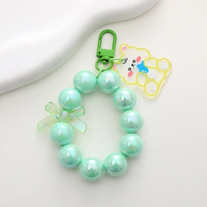 Detail of mint green pearlescent beaded keychain with cute bear and bow pendant
