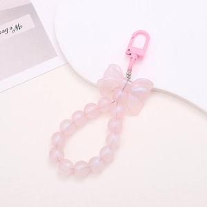 Detail of pink pearlescent bead phone charm with translucent acrylic bow and lobster clasp