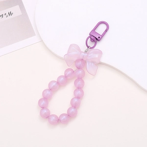 Purple pearlescent bead keychain featuring a matte resin bow and metal spring clasp