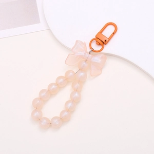 Detail of pink pearlescent beaded keychain with translucent bow and orange metal clasp