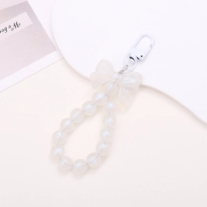 White beaded keychain with a matte bow and glossy pearl beads on a minimalist display