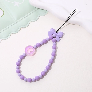 Detail shot of purple beaded phone strap with a bow accent and heart pendant