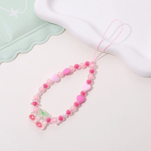 Detailed view of pink beaded phone charm with acrylic hearts and transparent cherry pendant