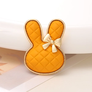 Detailansicht eines orangefarbenen Karomuster-Hasenanhängers mit goldener Schleife