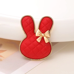 Detailansicht eines roten Kaninchen-Accessoires mit Goldschleife und gestepptem Muster