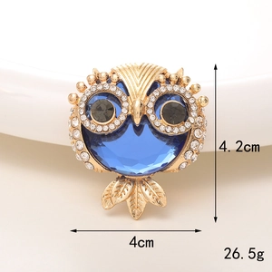 Macro detail of owl brooch with blue gemstone showing 4.2cm height and 4cm width
