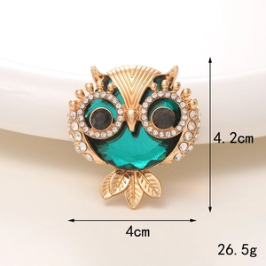 Detailed close-up of golden owl brooch with green gemstones and white rhinestones, 4.2x4cm