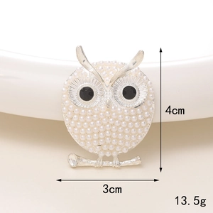 Macro view of silver owl brooch with white imitation pearls and dimensions 4x3cm