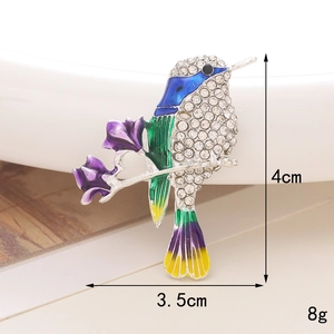 Macro view of colorful enamel hummingbird brooch showing 4cm height and 3.5cm width