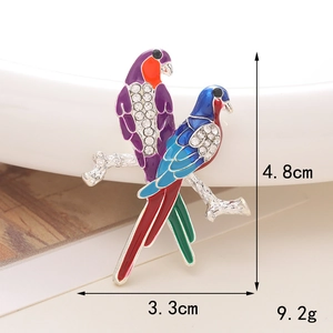 Detail view of parrot enamel brooch with crystals and size markings of 4.8cm by 3.3cm