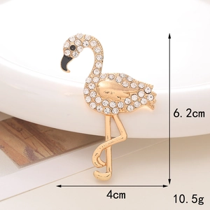 Detailed view of crystal flamingo charm brooch in champagne gold with size dimensions