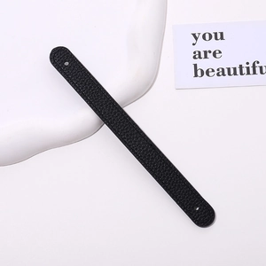 Close-up of black lychee-textured PU leather wrist strap with dual punched holes