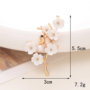 Elegant gold flower brooch with white petals and a small bird perched on branches