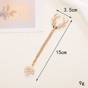 Detalle de un broche de cabeza de ciervo dorado con strass y una cadena larga de borlas