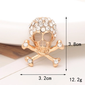 Dettaglio macro di un ciondolo per scarpe a teschio dorato con strass brillanti e misure