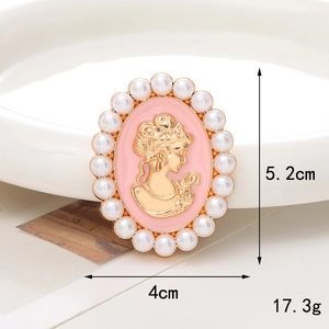 Dettaglio macro di una spilla cammeo vintage rosa con profilo dorato e perle bianche