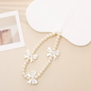 Detailed view of white pearl phone lanyard with three decorative bow accents for wrist strap