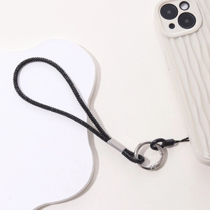 Detail of luxury black rhinestone phone strap with silver ring on white wavy case