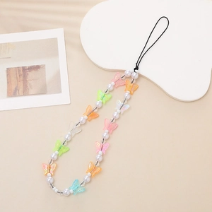 Detailed close-up of colorful iridescent bow bead phone charms and white pearls