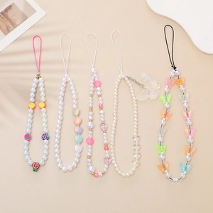 Detail shot of five colorful beaded phone straps with imitation pearls and fruit charms