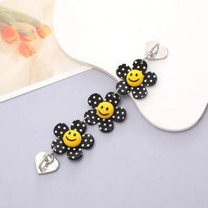 Close-up of DIY acrylic mobile chain with black polka dot flowers and heart buckles