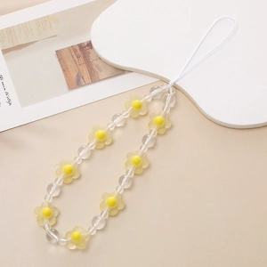 Close-up of matte yellow flower beads and clear acrylic spheres on a beaded phone strap