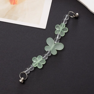 Detail of beaded mobile strap with frosted green flowers, butterfly, and metal screw clasp