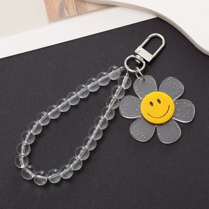 Close-up of translucent grey flower pendant with yellow smiley face on beaded wrist strap