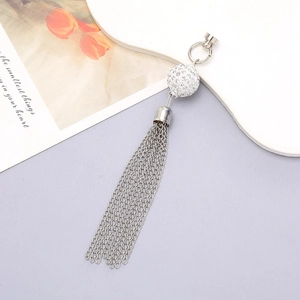 Detailed view of silver rhinestone ball tassel charm with magnetic buckle and chain fringe