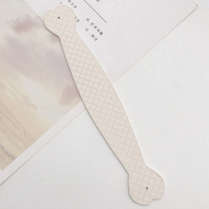 Close-up of cream leather strap with diamond lattice pattern and round holes