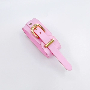 Detail view of pink leather wrist strap with gold buckle and adjustable metal rivets