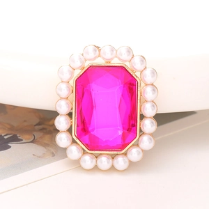 Macro-opname van een magenta edelsteen met witte parelrand in gouden zetting