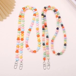 Colorful beaded phone charm with heart resin beads and metal lobster clasp on pink background
