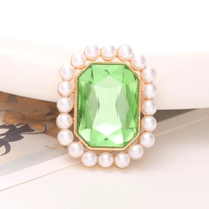 Detail van de smaragdgroene kristallen telefoonhouder met elegante parelafwerking