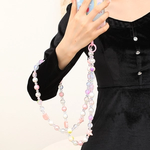 Détail de la dragonne de téléphone multicouche en perles roses avec cœurs et étoiles